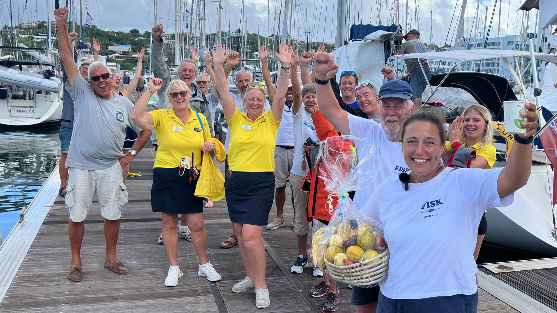Sailors and ARC yellow shirt team waving on the dock in Saint Lucia