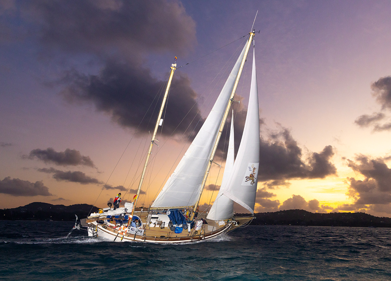 Classic German ketch Ostwind sails towards the ARC finish line with the sunset