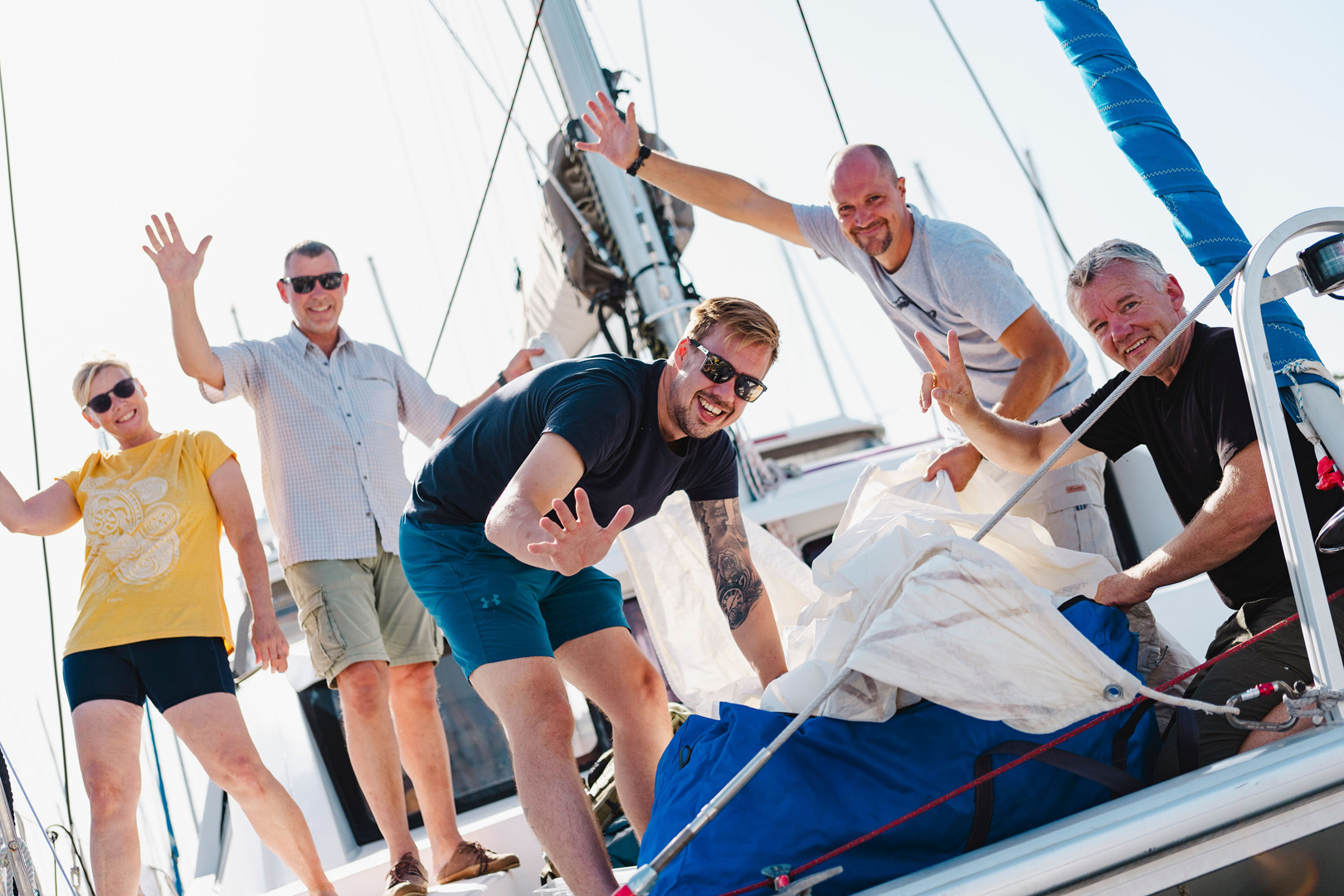 Men and women on a yacht crew wave as they prepare to take part in ARC+ 2024 from Las Palmas to Grenada via Cape Verdein