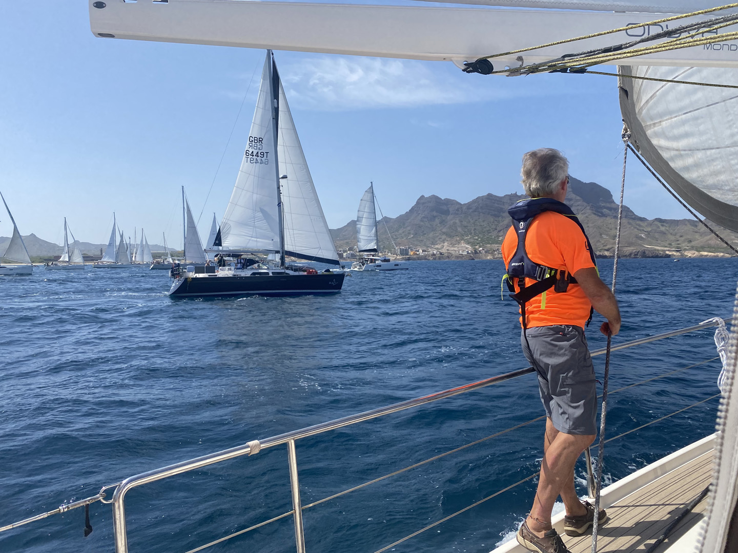A crewman on yacht Onava Mondiale watches the other yachts at the start of ARC+ 2023 from Cape Verde to Grenada