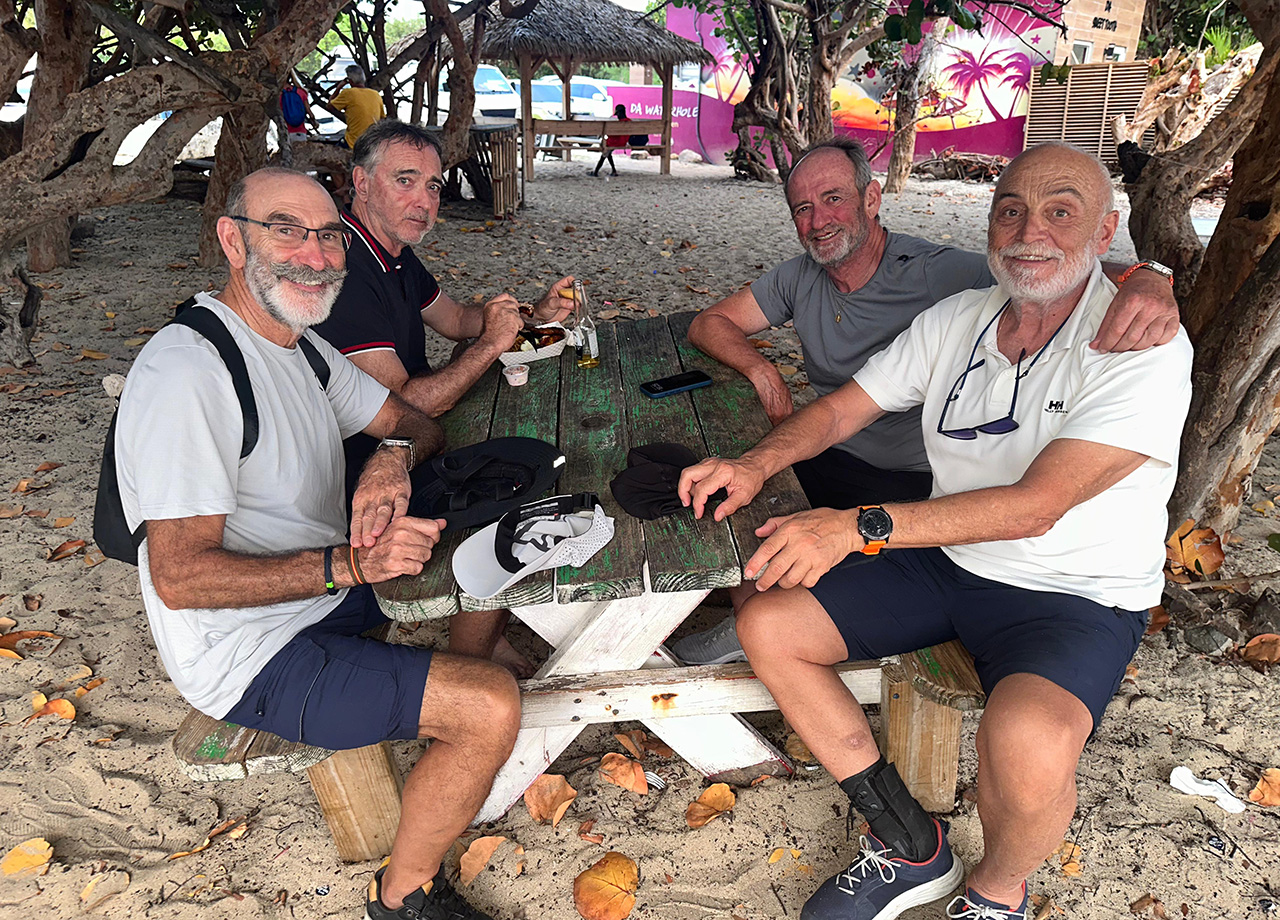 Crewmen from an ARC Europe yacht enjoy a beer on the beach in Sint Maarten