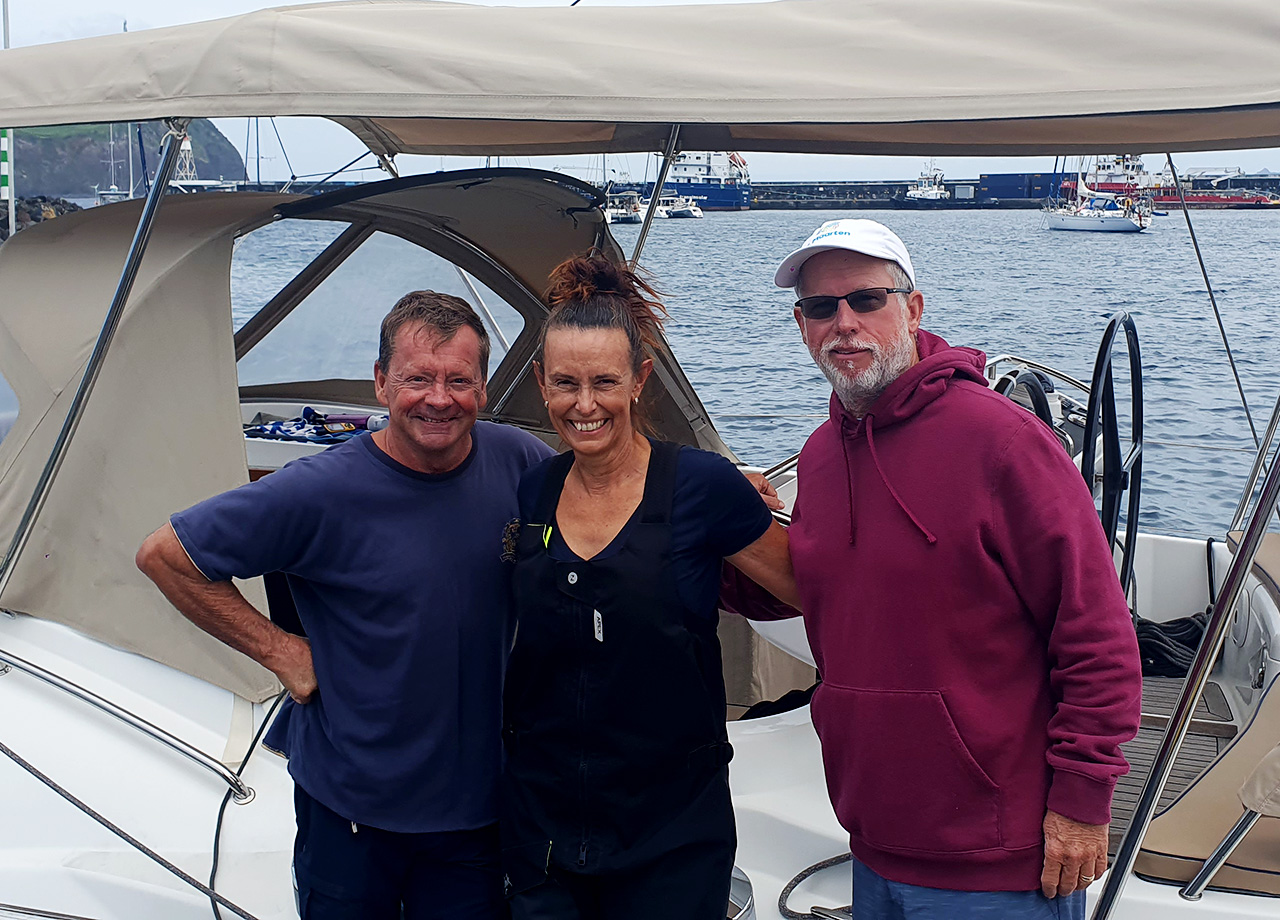 Two men and a woman crew on yacht Sophistikate happy to be in Horta Azores in ARC Europe 2025