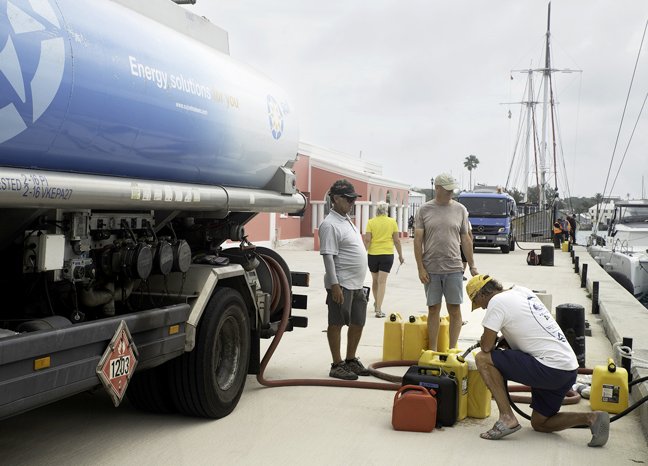 A crew member from an ARC Europe yacht fills diesel jerrycans from a fuel tanker in Bermuda