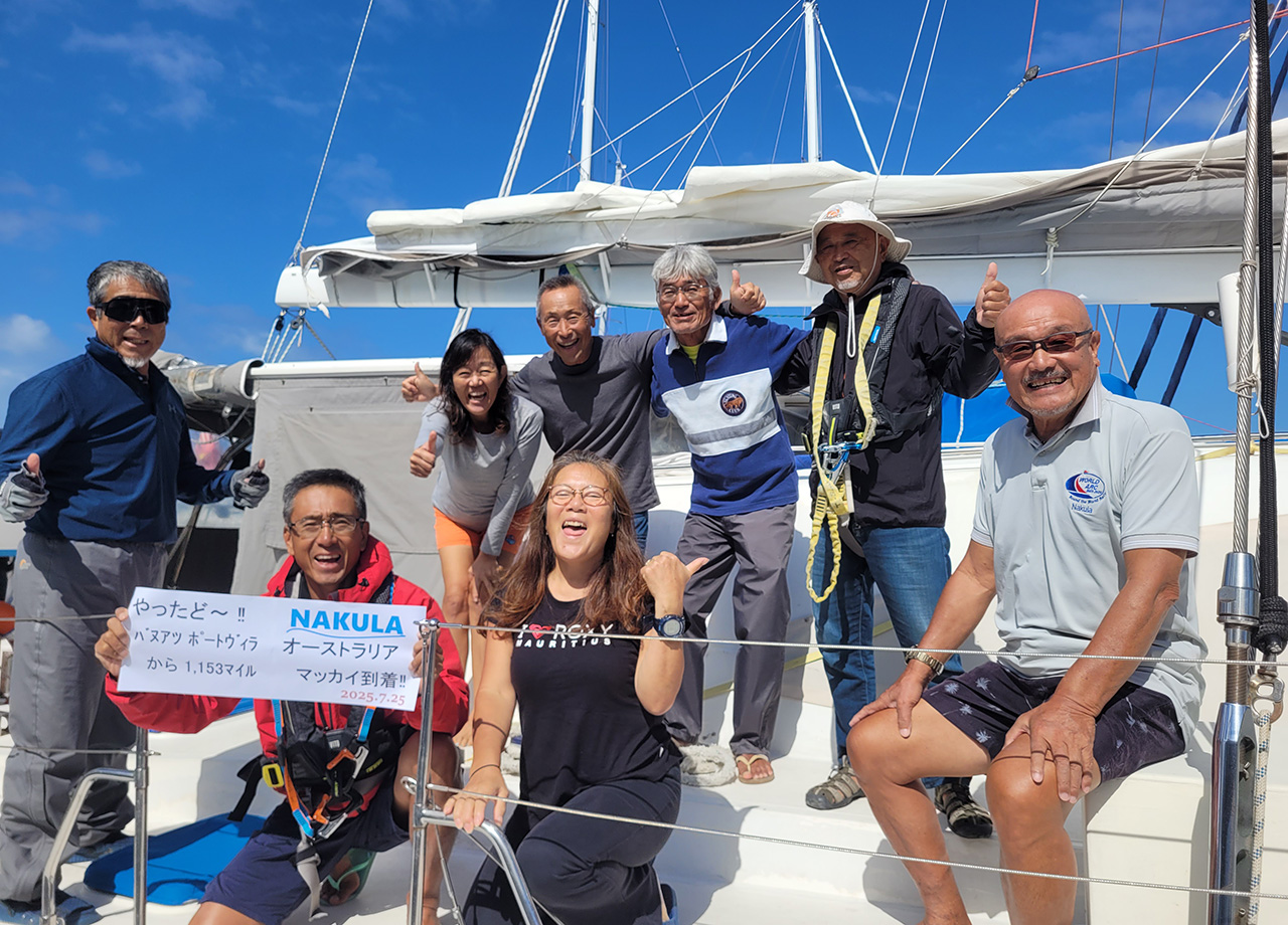 Eight Japanese men and women laugh on the deck of yacht Nakula as World ARC visits Mackay
