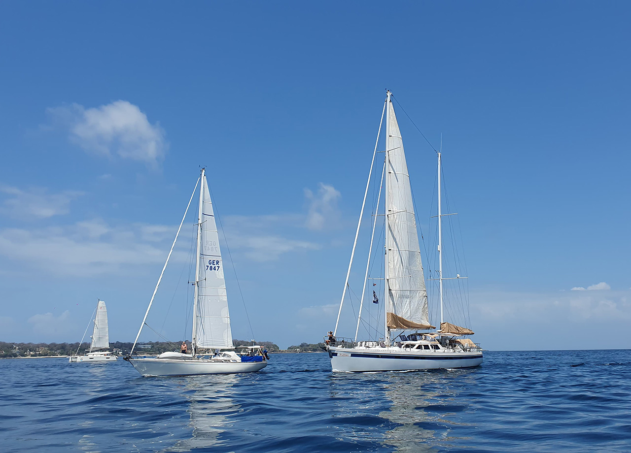 Yachts motor sail in calm conditions with blue sky for the World ARC start from Las Perlas