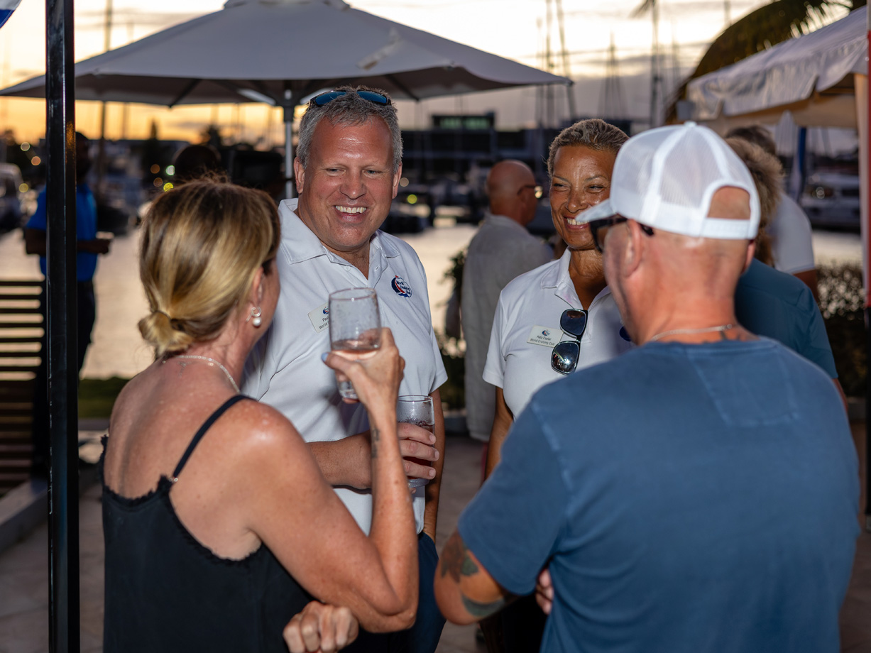 A groups of people chat at a party in the Caribbean