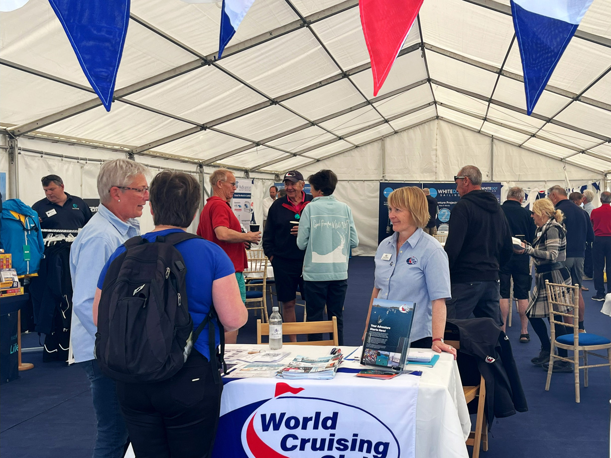 A crowd of people in a marquee for Bluewater Day. Red white and blue bunting and a World Cruising Club flag